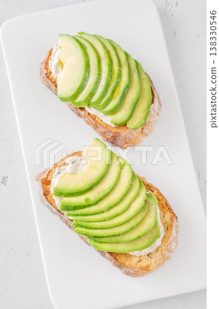 Avocado toast sandwiches with soft cheese on artisan bread fresh healthy meal Avocado toast sandwiches with soft cheese on artisan bread fresh healthy meal 138330546