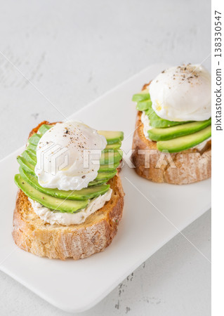 Avocado toast with poached eggs on artisan bread plate Avocado toast with poached eggs on artisan bread plate 138330547