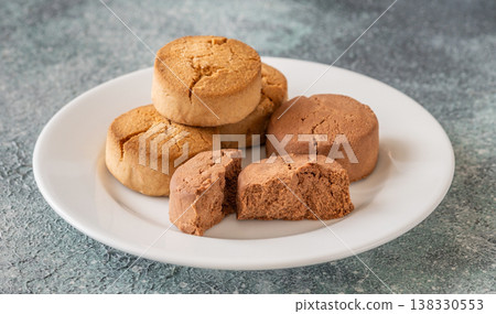 Spanish polvorones cookies on white plate with crumbly texture and rustic presentation Spanish polvorones cookies on white plate with crumbly texture and rustic presentation 138330553