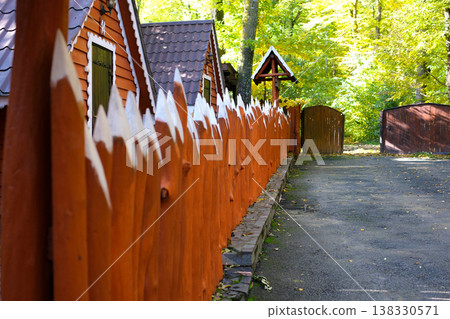 Wooden pointed fence Tall Wooden Fence with Pointed Pickets and Minimalist Decking 138330571