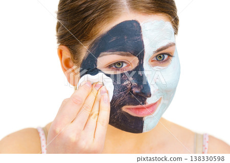 Girl remove black white mud mask from face Girl remove black white mud mask from face 138330598