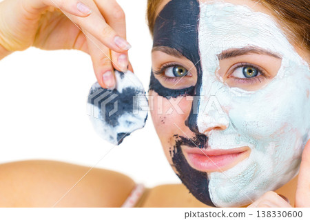 Girl remove black white mud mask from face Girl remove black white mud mask from face 138330600