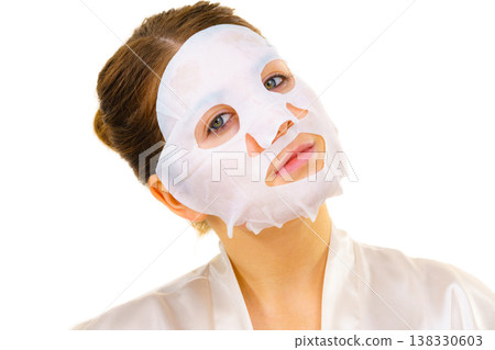 Woman applying sheet mask on face Woman applying sheet mask on face 138330603