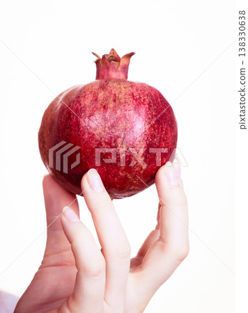 Female hand holds pomegranate fruits, isolated Female hand holds pomegranate fruits, isolated 138330638