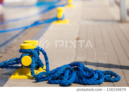 Sailing ropes tied around pins in sunlight Sailing ropes tied around pins in sunlight 138330679