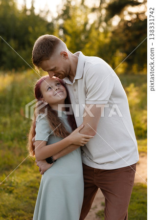 Sunlit Child Embraced. Daughter Basks In Sunlight With Affectionate Parental Care Around 138331742