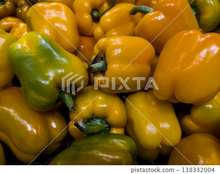 Top view of colorful mix of fresh organic yellow, orange and green bell peppers background pattern at farmers market 138332004