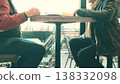 Two unrecognizable senior men talking while seated at a cafe table near a window 138332098