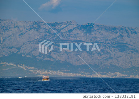 Tourist boat on Adriatic Sea with Biokovo Mountain Range Backdrop in Makarska riviera, Croatia 138332191