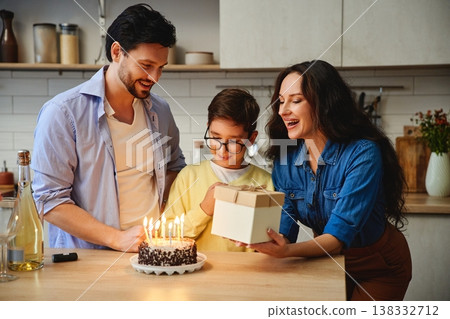 Family celebration with birthday cake and gifts in a cozy kitchen Family celebration with birthday cake and gifts in a cozy kitchen 138332712