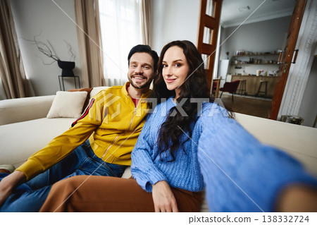 Happy couple enjoying a cozy afternoon together at home in warm sweaters 138332724