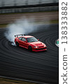 Red Sports Car Drifting On A Racetrack With Smoke Creating Dynamic Motion and High Speed Action 138333882