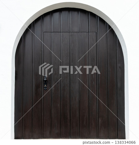 Arched Dark Wooden Door on White Wall 138334066