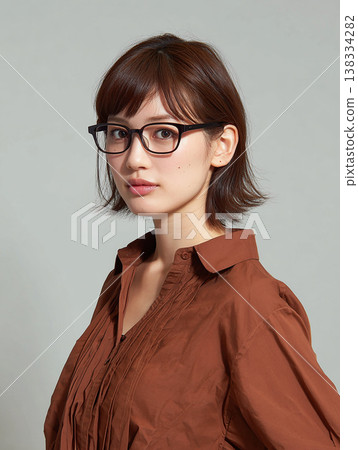 一位成年女性戴著眼鏡，目光專注地凝視著前方。 138334282