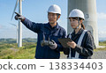 Workers inspect wind turbines using drones. 138334403