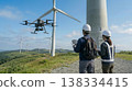 Workers inspect wind turbines using drones. 138334415