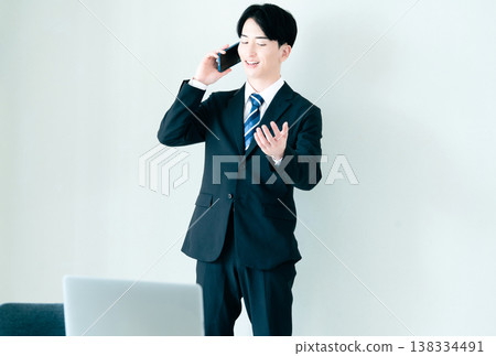 一個年輕的商人在辦公室打電話 138334491