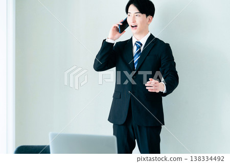 一個年輕的商人在辦公室打電話 138334492