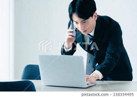 一個年輕的商人在辦公室打電話 138334495