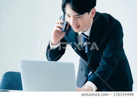 一個年輕的商人在辦公室打電話 138334496