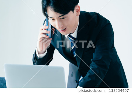 一個年輕的商人在辦公室打電話 138334497