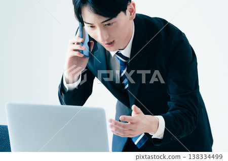 一個年輕的商人在辦公室打電話 138334499