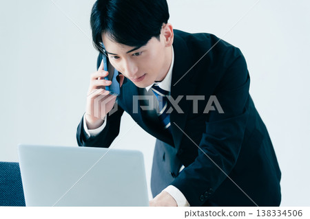 一個年輕的商人在辦公室打電話 138334506