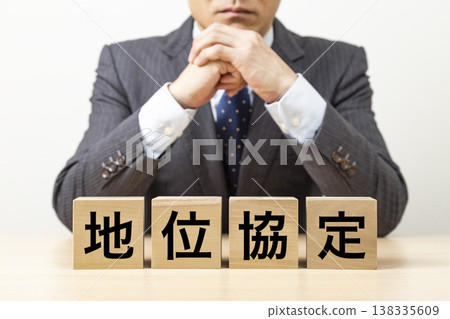 A block with the words "Status of Forces Agreement" written on it and a businessman A block with the words "Status of Forces Agreement" written on it and a businessman 138335609