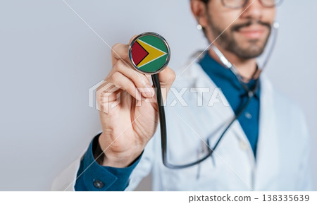 Doctor holding stethoscope with Guyana flag. Guyana health and care concept, Guyana flag on stethoscope Doctor holding stethoscope with Guyana flag. Guyana health and care concept, Guyana flag on stethoscope 138335639