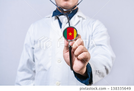 Doctor hands holding stethoscope with Cameroon flag. Cameroon health and care concept 138335649