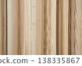 Close-up of light-colored wooden planks arranged vertically. Natural wood grain texture on timber boards for construction and carpentry. High-quality lumber material for interior design. 138335867