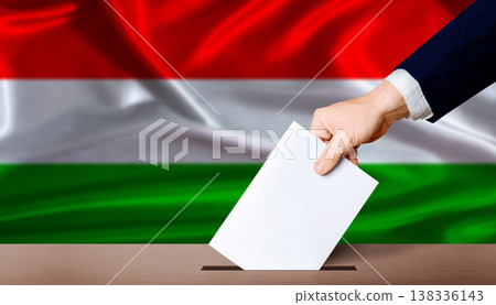 Hand placing a ballot in ballot box with the Hungarian flag in the background. Hungary parliamentary vote 2026 138336143