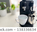一台黑色義式咖啡機、白色咖啡杯和一壺蒸氣牛奶——咖啡館風格的咖啡。 138336634