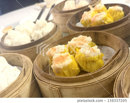 Steamed dim sum dumplings in bamboo baskets, a popular Chinese delicacy Steamed dim sum dumplings in bamboo baskets, a popular Chinese delicacy 138337205