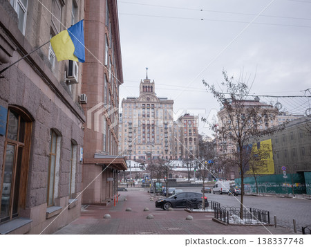 [Ukraine] A view of a historical building and the Ukrainian flag displayed on a wall from the sidewalk of a main street in Kyiv, the capital of Ukraine. 138337748