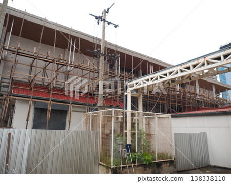 Construction scaffolding metal fence urban building site daytime scene 138338110