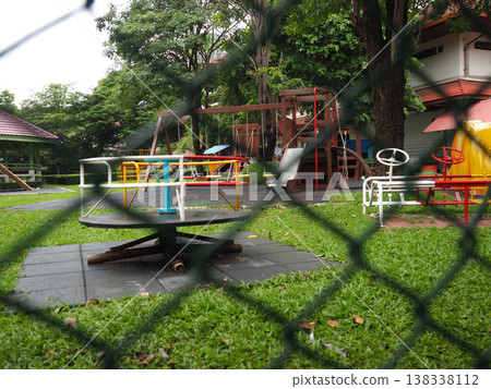 Playground swing slide roundabout empty green grass tree Playground swing slide roundabout empty green grass tree 138338112