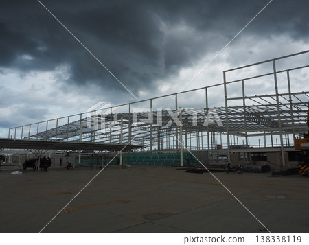 Industrial construction steel structure warehouse frame dark storm cloud wide angle view Industrial construction steel structure warehouse frame dark storm cloud wide angle view 138338119