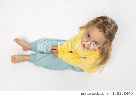 Portrait of beautiful cute little toddler girl. Child with funny face in yellow sweatshirt. Pretty smile kid in studio on white background. High quality photo Portrait of beautiful cute little toddler girl. Child with funny face in yellow sweatshirt. Pretty smile kid in studio on white background. High quality photo 138338440