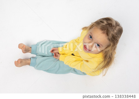 Portrait of beautiful cute little toddler girl. Child with funny face in yellow sweatshirt. Pretty smile kid in studio on white background. High quality photo Portrait of beautiful cute little toddler girl. Child with funny face in yellow sweatshirt. Pretty smile kid in studio on white background. High quality photo 138338448