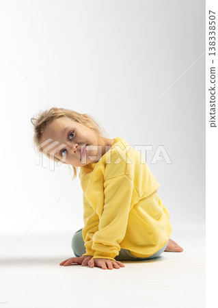 Portrait of beautiful cute little toddler girl. Child with funny face in yellow sweatshirt. Pretty smile kid in studio on white background. High quality photo Portrait of beautiful cute little toddler girl. Child with funny face in yellow sweatshirt. Pretty smile kid in studio on white background. High quality photo 138338507