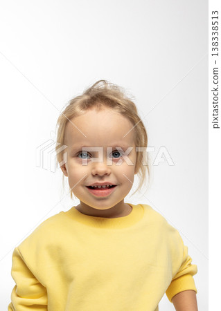Portrait of beautiful cute little toddler girl. Child with funny face in yellow sweatshirt. Pretty smile kid in studio on white background. High quality photo Portrait of beautiful cute little toddler girl. Child with funny face in yellow sweatshirt. Pretty smile kid in studio on white background. High quality photo 138338513