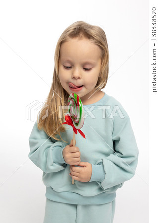 Portrait of funny little blonde girl with sweets lollipop in her hand. High quality photo Portrait of funny little blonde girl with sweets lollipop in her hand. High quality photo 138338520