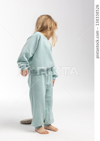 Portrait of beautiful cute little toddler girl. Child with funny face in mint sweatshirt and hat. Pretty smile kid in studio on white background. Portrait of beautiful cute little toddler girl. Child with funny face in mint sweatshirt and hat. Pretty smile kid in studio on white background. 138338526