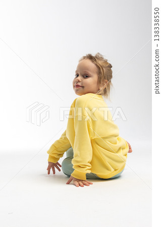Portrait of beautiful cute little toddler girl. Child with funny face in yellow sweatshirt. Pretty smile kid in studio on white background. High quality photo Portrait of beautiful cute little toddler girl. Child with funny face in yellow sweatshirt. Pretty smile kid in studio on white background. High quality photo 138338550