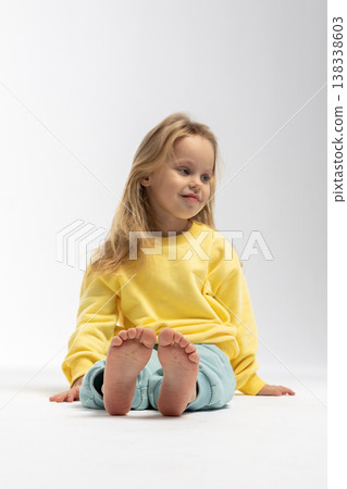 Portrait of beautiful cute little toddler girl. Child with funny face in yellow sweatshirt. Pretty smile kid in studio on white background. High quality photo Portrait of beautiful cute little toddler girl. Child with funny face in yellow sweatshirt. Pretty smile kid in studio on white background. High quality photo 138338603