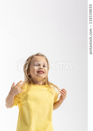 Portrait of beautiful cute little toddler girl. Child with funny face in yellow sweatshirt jumps. Pretty smile kid in studio on white background. High quality photo Portrait of beautiful cute little toddler girl. Child with funny face in yellow sweatshirt jumps. Pretty smile kid in studio on white background. High quality photo 138338650