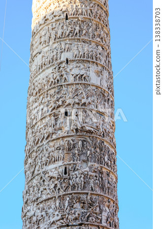 Monument Column of Marcus Aurelius with detailed relief surface and sculpture crowning column surrounded by urban architecture and cars in Italy capital, Rome, Italy Monument Column of Marcus Aurelius with detailed relief surface and sculpture crowning column surrounded by urban architecture and cars in Italy capital, Rome, Italy 138338703