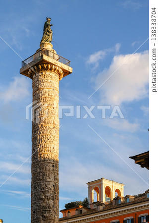 Monument Column of Marcus Aurelius with detailed relief surface and sculpture crowning column surrounded by urban architecture and cars in Italy capital, Rome, Italy Monument Column of Marcus Aurelius with detailed relief surface and sculpture crowning column surrounded by urban architecture and cars in Italy capital, Rome, Italy 138338704