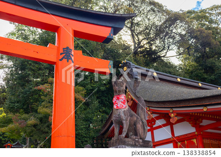 Fox statue with red bib and symbolic key seated on stone pedestal at Fushimi Inari Shrine in Kyoto, Japan Fox statue with red bib and symbolic key seated on stone pedestal at Fushimi Inari Shrine in Kyoto, Japan 138338854